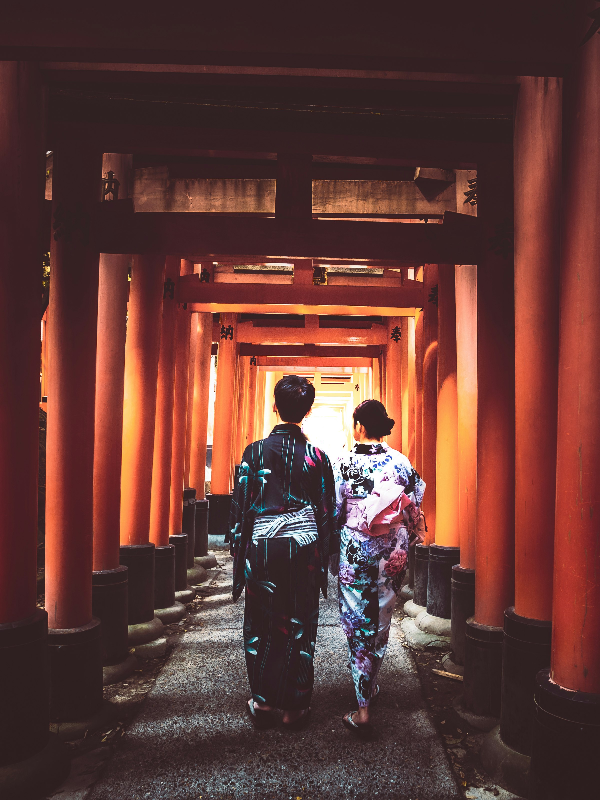 woman in white and red floral kimono standing on gray concrete floor